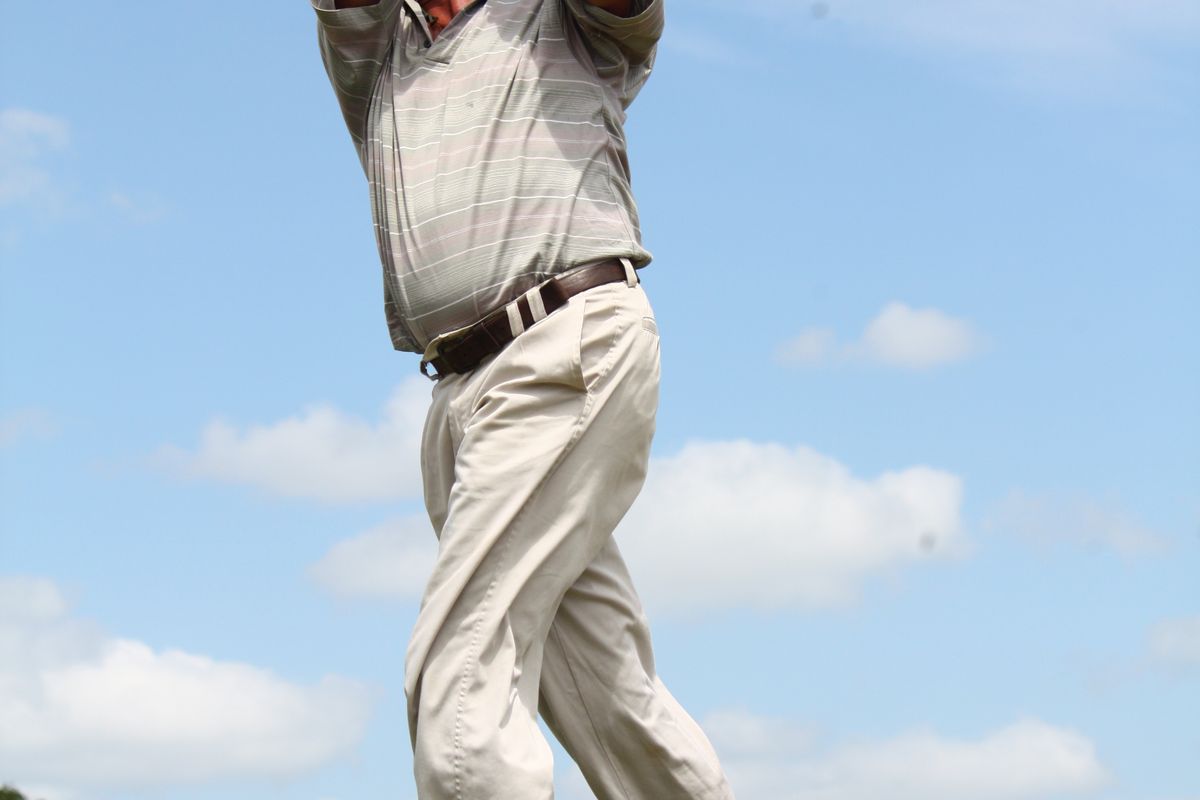 Golfer mid-swing illustrating the rotation TPI golf fitness screening assesses